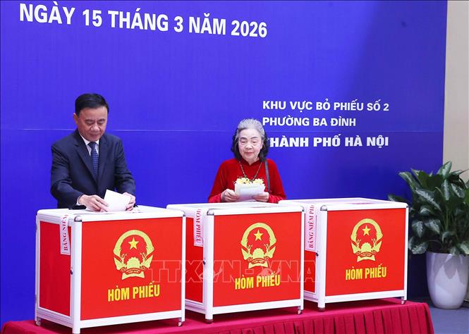 Đồng chí Trần Cẩm Tú, Ủy viên Bộ Chính trị, Thường trực Ban Bí thư và cử tri bỏ phiếu bầu cử tại Khu vực bỏ phiếu số 02 phường Ba Đình, thành phố Hà Nội. Ảnh: Văn Điệp – TTXVN