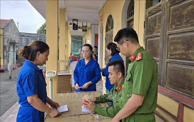 Các cử tri là người bị tạm giam, tạm giữ đóng dấu hoàn thành công tác bầu cử. Ảnh: Thanh Vân-TTXVN 