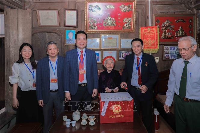 Cử tri Chu Thị Nhớn, 102 tuổi, thuộc gia đình có công với cách mạng, phấn khởi sau khi thực hiện quyền bầu cử tại nhà nhờ sự hỗ trợ của Tổ bầu cử lưu động phường Phúc Lợi. Ảnh: Phan Phương – TTXVN