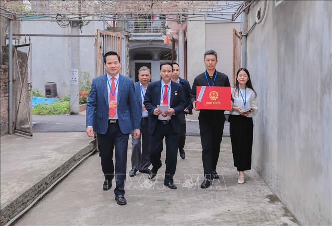 Ông Nguyễn Thế Thạch, Bí thư Đảng ủy, Chủ tịch Ủy ban Bầu cử phường Phúc Lợi trực tiếp cùng Tổ bầu cử đơn vị bầu cử số 2 đến nhà cử tri Chu Thị Nhớn, 102 tuổi, gia đình có công với cách mạng, hỗ trợ thực hiện quyền bầu cử. Ảnh: Phan Phương – TTXVN