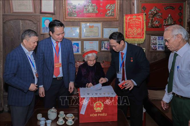 Cử tri Chu Thị Nhớn, 102 tuổi, thuộc gia đình có công với cách mạng, phấn khởi sau khi thực hiện quyền bầu cử tại nhà nhờ sự hỗ trợ của Tổ bầu cử lưu động phường Phúc Lợi. Ảnh: Phan Phương – TTXVN