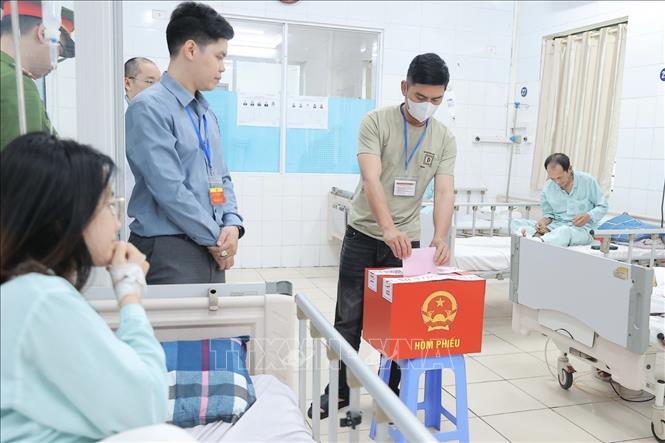 Cử tri là người nhà bệnh nhân tại Bệnh viện Hữu nghị Việt Đức bỏ phiếu lưu động, thuộc khu vực bỏ phiếu số 3, phường Hoàn Kiếm. Ảnh: Minh Quyết - TTXVN