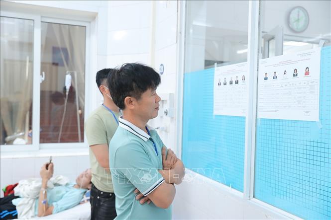 Người nhà và bệnh nhân tìm hiểu thông tin của đại biểu ứng cử trong danh sách niêm yết tại điểm bầu cử lưu động Bệnh viện Hữu nghị Việt Đức. Ảnh: Minh Quyết - TTXVN