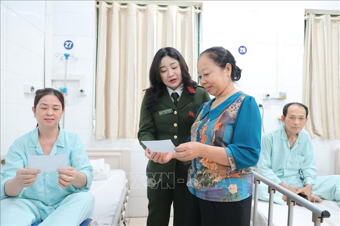 Thành viên tổ bầu cử khu vực bỏ phiếu số 3 phường Hoàn Kiếm phối hợp cùng đoàn viên thanh niên bệnh viện phát thẻ cử tri tại điểm bầu cử lưu động Bệnh viện Hữu nghị Việt Đức. Ảnh: Minh Quyết - TTXVN