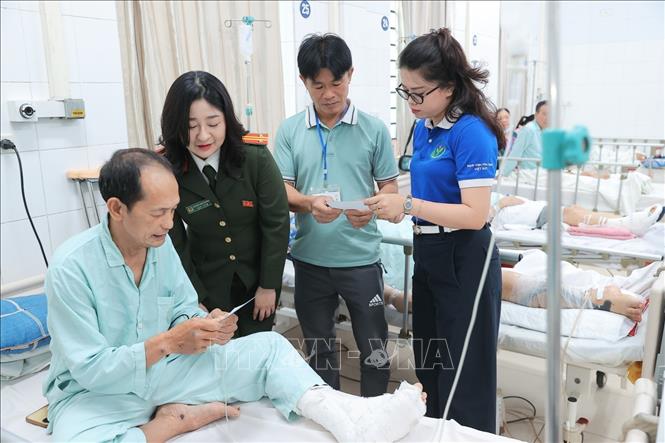 Thành viên tổ bầu cử thuộc khu vực bỏ phiếu số 3 phường Hoàn Kiếm phối hợp cùng đoàn viên thanh niên bệnh viện phát thẻ cử tri tại điểm bầu cử lưu động Bệnh viện Hữu nghị Việt Đức. Ảnh: Minh Quyết - TTXVN