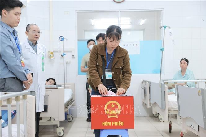 Cử tri là người nhà bệnh nhân bỏ phiếu tại điểm bầu cử lưu động Bệnh viện Hữu nghị Việt Đức thuộc khu vực bỏ phiếu số 3, phường Hoàn Kiếm. Ảnh: Minh Quyết - TTXVN