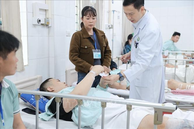 Bác sĩ Bệnh viện Việt Đức phát thẻ cử tri cho bệnh nhân và người nhà tham gia bầu cử tại điểm bầu cử lưu động Bệnh viện Hữu nghị Việt Đức. Ảnh: Minh Quyết - TTXVN