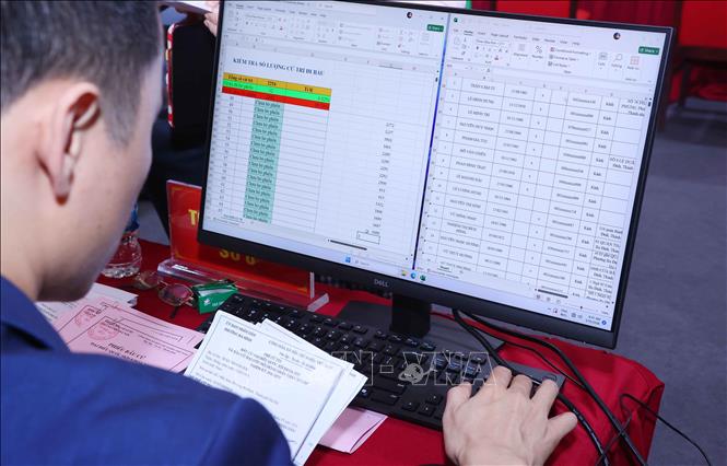 Tổ bầu cử rà soát thẻ cử tri và nhập vào máy tính tại Khu vực bỏ phiếu số 02 phường Ba Đình, thành phố Hà Nội. Ảnh: Văn Điệp – TTXVN