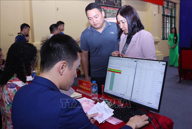 Tổ bầu cử rà soát thẻ cử tri và nhập vào máy tính tại Khu vực bỏ phiếu số 02 phường Ba Đình, thành phố Hà Nội. Ảnh: Văn Điệp – TTXVN