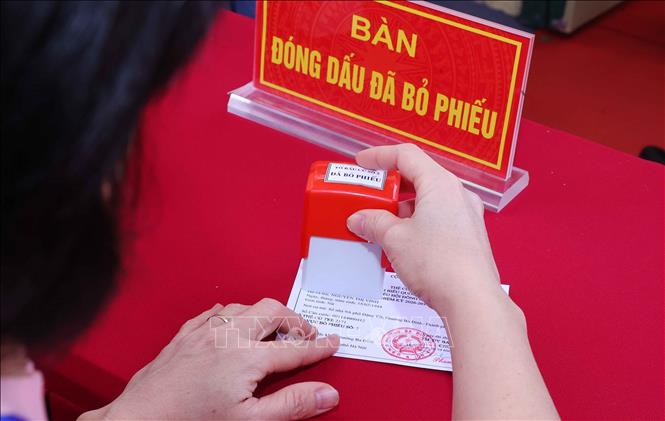 Tổ bầu cử đóng dấu thẻ cử tri đã thực hiện xong quyền và nghĩa vụ công dân tại Khu vực bỏ phiếu số 02 phường Ba Đình, thành phố Hà Nội. Ảnh: Văn Điệp – TTXVN
