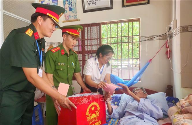 Tổ bầu cử ấp Thiềng Liềng (xã đảo Thạnh An) mang thùng phiếu đến nhà hỗ trợ hai cử tri đặc biệt Nguyễn văn Thanh (Sinh năm 1942) và Trần Thị Nết (Sinh năm 1944) thực hiện quyền công dân. Ảnh: Hữu Duyên - TTXVN