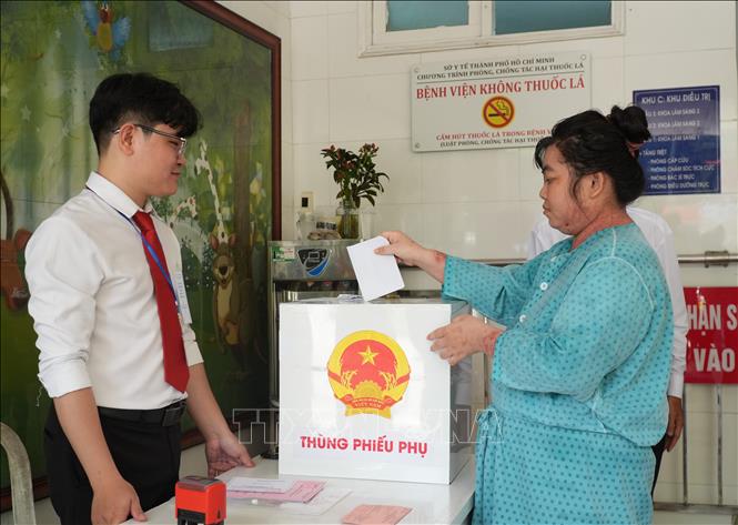 Cử tri Nguyễn Thị Thúy được hỗ trợ, bỏ phiếu tại Bệnh viện Da liễu TP. Hồ Chí Minh. Ảnh: Hữu Duyên - TTXVN