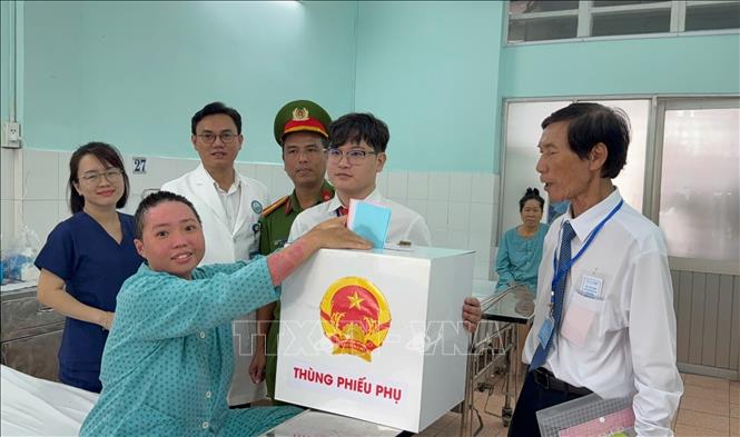 Cử tri Trần Thị Thúy Hiền (bệnh nhân tại Bệnh viện Da liễu TP. Hồ Chí Minh) hạnh phúc được bỏ phiếu khi còn đang trong giai đoạn điều trị. Ảnh: Hữu Duyên - TTXVN