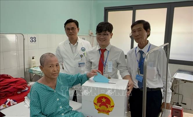 Cử tri Nguyễn Thị Thuận (sinh năm 1969, quê Lâm Đồng) là bệnh nhân ở Bệnh viện Da liễu TP.Hồ Chí Minh được hỗ trợ bỏ phiếu tại giường bệnh. Ảnh: Hữu Duyên - TTXVN