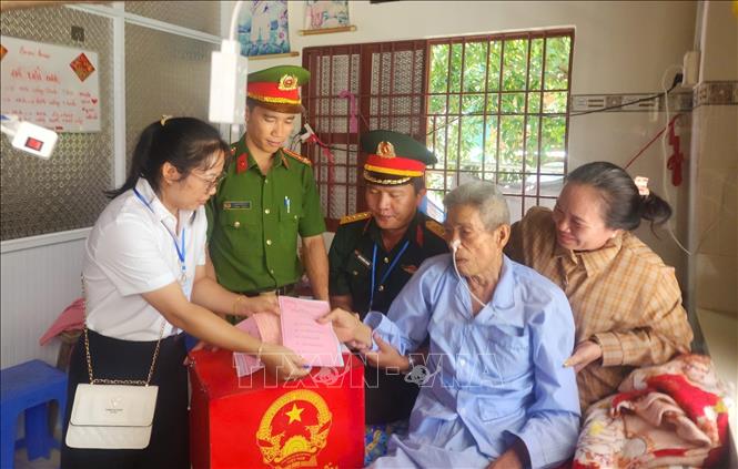 Tổ bầu cử ấp Thiềng Liềng (xã đảo Thạnh An) mang thùng phiếu đến nhà hỗ trợ hai cử tri đặc biệt Nguyễn văn Thanh (Sinh năm 1942) và Trần Thị Nết (Sinh năm 1944) thực hiện quyền công dân. Ảnh: Hữu Duyên - TTXVN