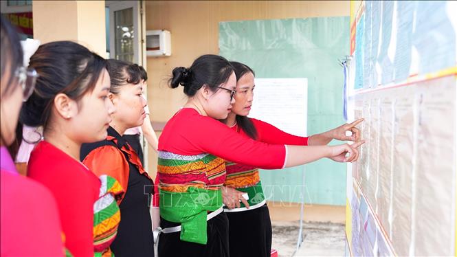 Cử tri người đồng bào dân tộc Thái xem danh sách ứng cử viên đại biểu Quốc hội và HĐND các cấp tại điểm bầu cử ở ấp Phước Trung, xã Long Chữ, tỉnh Tây Ninh. Ảnh: Minh Phú – TTXVN