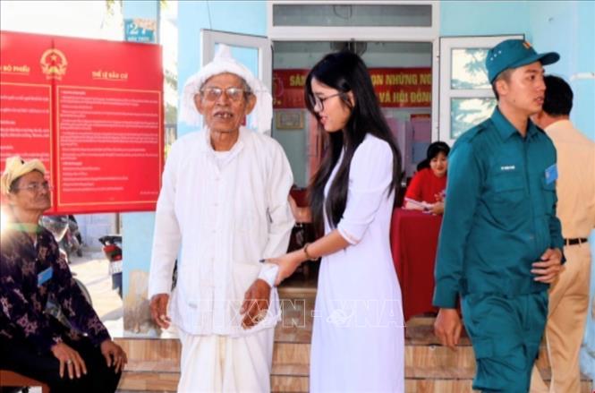 Cụ Dương Tình (83 tuổi, ở làng gốm truyền thống Bàu Trúc, xã Ninh Phước) cùng cháu nội hoàn thành sớm bỏ phiếu trong sáng sớm  ngày bầu cử. Ảnh: Công Thử - TTXVN
