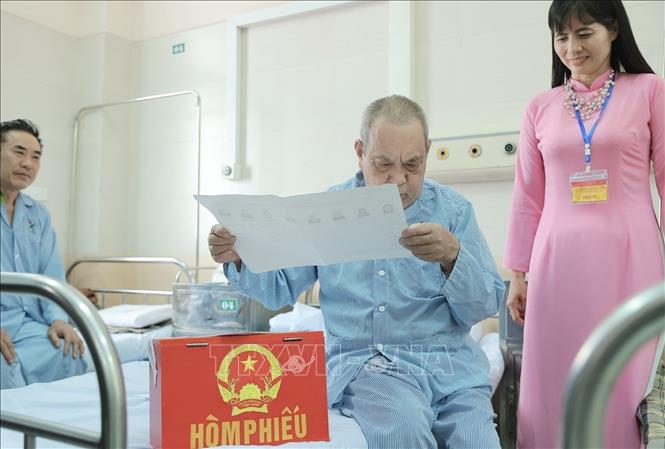 Cử tri tìm hiểu thông tin về đại biểu ứng cử trước khi bỏ phiếu bầu. Ảnh: Minh Quyết - TTXVN