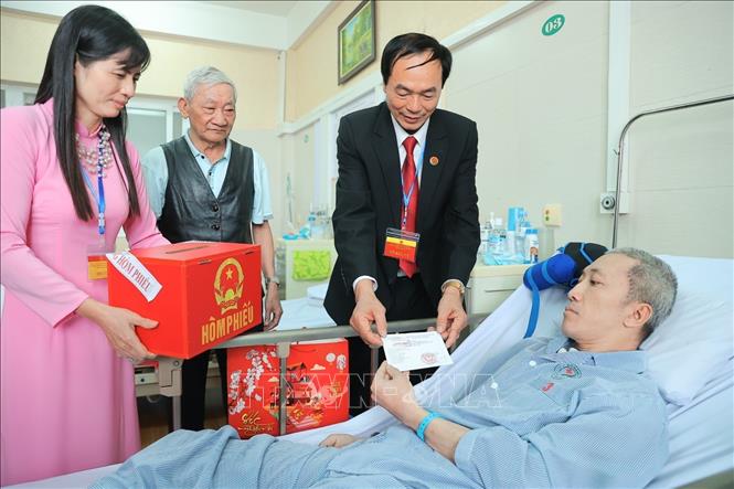 Thành viên tổ bầu cử phát thẻ cử tri cho các bệnh nhân. Ảnh: Minh Quyết - TTXVN