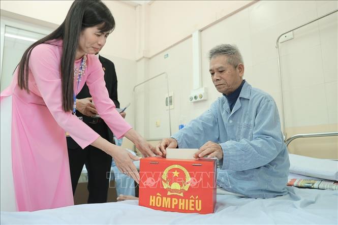 Cử tri là bệnh nhân đang điều trị bỏ phiếu tại điểm bầu cử lưu động Bệnh viện đa khoa Đức Giang chiều 15/3. Ảnh: Minh Quyết - TTXVN