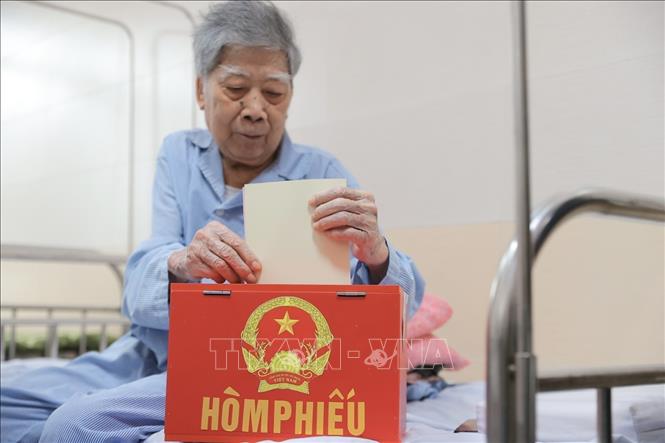 Cử tri là bệnh nhân đang điều trị bỏ phiếu tại điểm bầu cử lưu động Bệnh viện đa khoa Đức Giang chiều 15/3. Ảnh: Minh Quyết - TTXVN