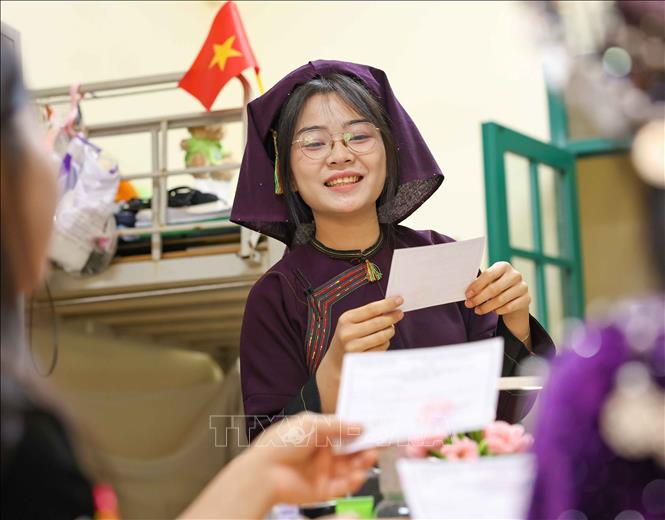 Mạc Thị Dậu (dân tộc Nùng, sinh viên K73, Khoa Việt Nam học) không giấu nổi cảm xúc lần đầu được cầm trên tay tấm thẻ cử tri của mình. Ảnh: Thanh Tùng - TTXVN