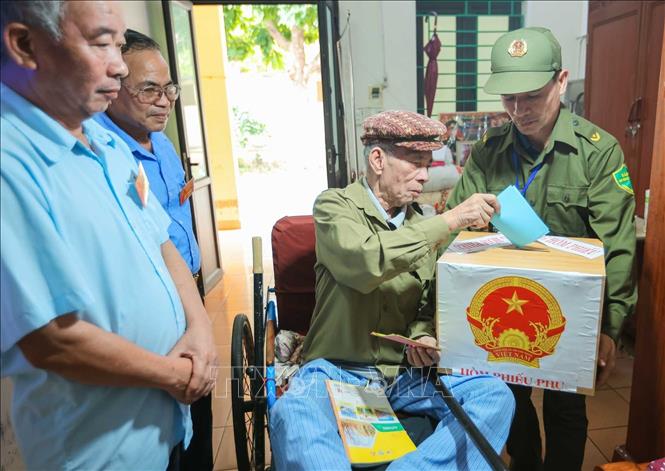 Cử tri Mai Văn Mỳ  (sinh năm 1948, thương binh hạng ¼, tỷ lệ thương tật 91%) bỏ phiếu tại nơi cư trú. Ảnh: Hoàng Hiếu - TTXVN 