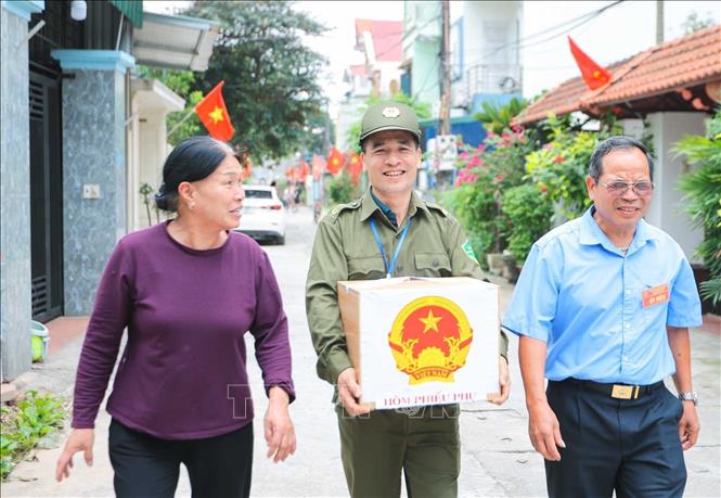Các thành viên tổ bầu cử số 10, đơn vị bầu cử số 3 trực tiếp mang hòm phiếu phụ đến nơi cư trú của các thương binh, bệnh binh nặng gặp nhiều hạn chế trong việc đi lại, để các cử tri “đặc biệt” được thực hiện đầy đủ quyền và nghĩa vụ công dân, góp phần tham gia vào ngày hội lớn của non sông. Ảnh: Hoàng Hiếu - TTXVN