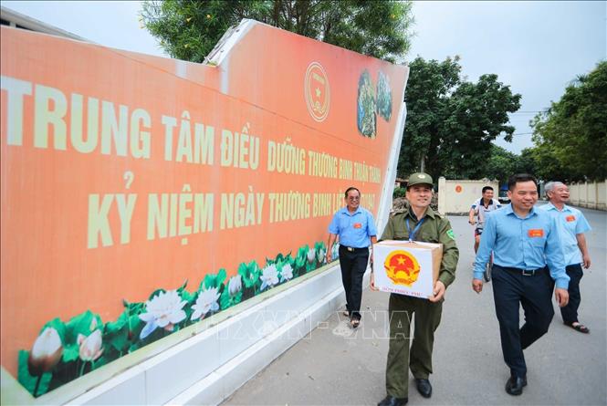 Các thành viên tổ bầu cử số 10, đơn vị bầu cử số 3 trực tiếp mang hòm phiếu phụ đến nơi cư trú của các thương binh, bệnh binh nặng gặp nhiều hạn chế trong việc đi lại, để các cử tri “đặc biệt” được thực hiện đầy đủ quyền và nghĩa vụ công dân, góp phần tham gia vào ngày hội lớn của non sông. Ảnh: Hoàng Hiếu - TTXVN