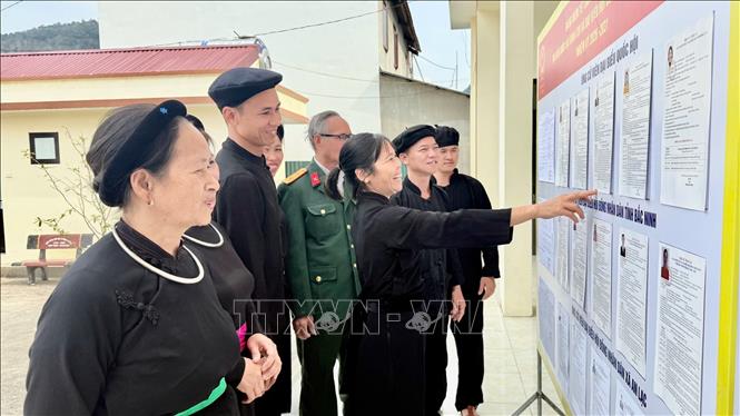 Đồng bào dân tộc Tày ở thôn Nà Ó, xã An Lạc, tỉnh Bắc Ninh xem danh sách các ứng cử viên đại biểu Quốc hội và HĐND. Ảnh: Việt Hùng - TTXVN