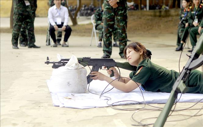 Giáo viên tham gia nội dung thi bắn súng tiểu liên AK bằng máy bắn tập. Ảnh: Hoàng Hùng - TTXVN