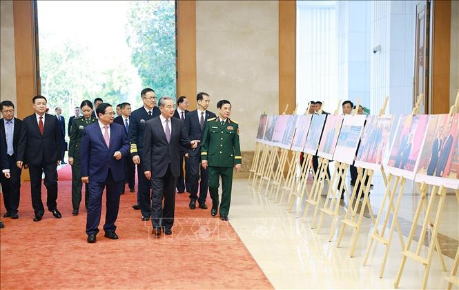 Thủ tướng Phạm Minh Chính và Bộ trưởng các Bộ Ngoại giao, Quốc phòng, Công an Trung Quốc tham quan trưng bày ảnh về quan hệ hợp tác giữa hai nước do Thông tấn xã Việt Nam thực hiện. Ảnh: Dương Giang-TTXVN
