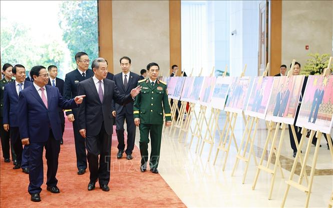 Thủ tướng Phạm Minh Chính và Bộ trưởng các Bộ Ngoại giao, Quốc phòng, Công an Trung Quốc tham quan trưng bày ảnh về quan hệ hợp tác giữa hai nước do Thông tấn xã Việt Nam thực hiện. Ảnh: Dương Giang-TTXVN
