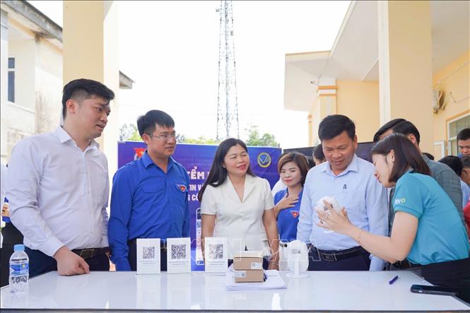 Đoàn viên thanh niên phổ cập tài khoản thanh toán điện tử cho người dân xã Sơn Tiến. Ảnh: Hoàng Ngà - TTXVN