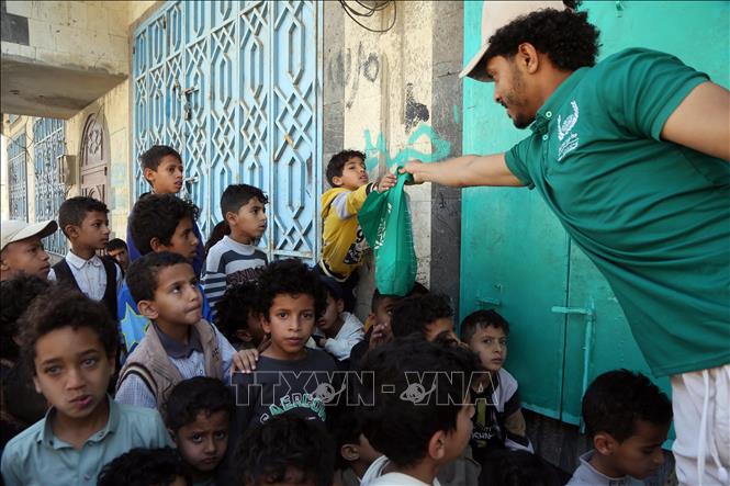 Tình nguyện viên phân phát thực phẩm cứu trợ cho các em nhỏ tại Sanaa, Yemen, ngày 15/3/2026. Ảnh: THX/TTXVN