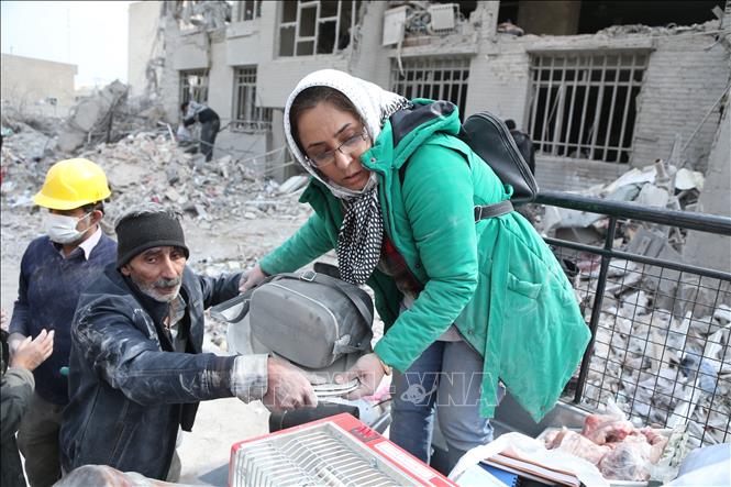 Người dân tìm kiếm đồ dùng thiết yếu bị chôn vùi dưới đống đổ nát sau vụ tấn công tại Tehran, Iran. Ảnh: THX/TTXVN