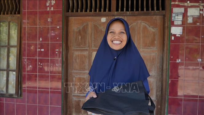 Chị Siti Maisyaroh, một bà mẹ đang cho con bú, phấn khởi khi nhận khẩu phần hỗ trợ dinh dưỡng. Ảnh: Đỗ Quyên – PV TTXVN tại Indonesia