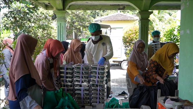 Nhân viên của Trạm y tế Posyandu tham gia phân phát các hộp đồ ăn. Ảnh: Đỗ Quyên – PV TTXVN tại Indonesia