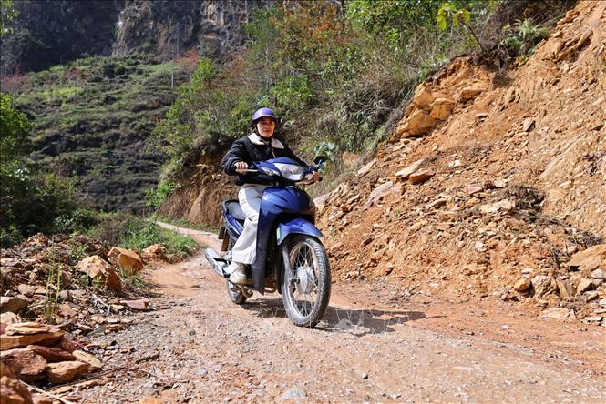 Để tới được điểm trường trong điều kiện giao thông vùng cao nhiều khó khăn, cô giáo Vàng Thị Tro phải di chuyển trên những con đường chênh vênh bên sườn núi. Ảnh: Minh Đức - TTXVN