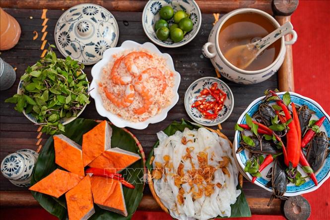 Bánh được cuộn nhẹ, rắc hành phi vàng ruộm và chấm nước mắm pha khéo léo với cà cuống và ăn kèm chả, rau thơm.  Ảnh: Khánh Hoà - TTXVN