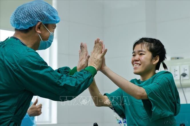 Niềm vui của bác sĩ và bệnh nhân P.A.T (bên phải) khi sức khỏe tiến triển tốt, hồi phục nhanh sau ca phẫu thuật phổi. Ảnh: Minh Quyết - TTXVN