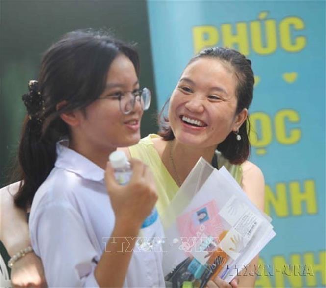 Phụ huynh mừng rỡ đón thí sinh sau khi hoàn thành môn thi tại Kỳ thi tuyển sinh vào lớp 10 THPT công lập năm học 2020 - 2021 tại Hà Nội. Ảnh: Thanh Tùng - TTXVN