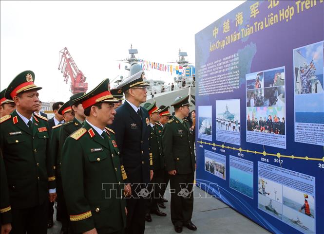 Đại tướng Phan Văn Giang và Thượng tướng Đổng Quân xem một số hình ảnh về 20 năm tuần tra liên hợp trên vùng biển Vịnh Bắc bộ giữa Hải quân hai nước. Ảnh: Trọng Đức - TTXVN