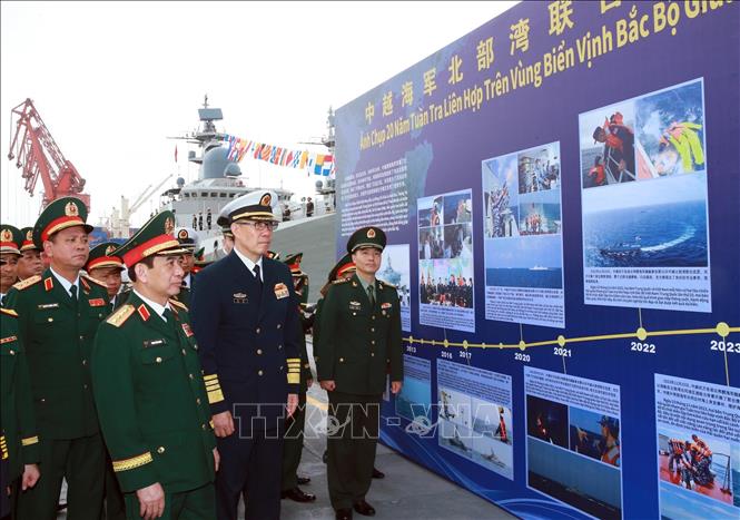 Đại tướng Phan Văn Giang và Thượng tướng Đổng Quân xem một số hình ảnh về 20 năm tuần tra liên hợp trên vùng biển Vịnh Bắc bộ giữa Hải quân hai nước. Ảnh: Trọng Đức - TTXVN