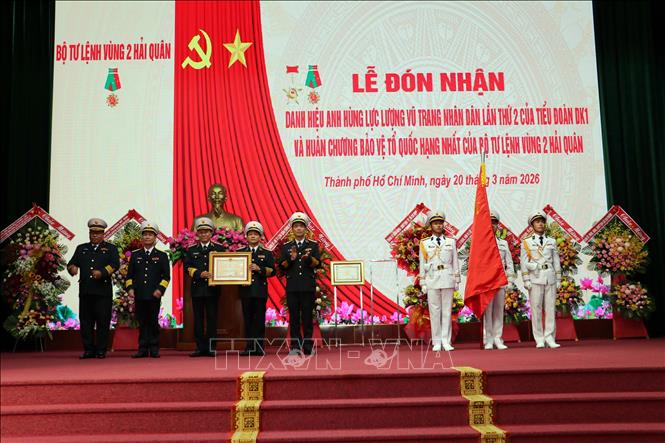 Phó Đô đốc Nguyễn An Phong gắn Huân chương Bảo vệ Tổ quốc hạng Nhất lên Quân kỳ quyết thắng và trao bằng Huân chương Bảo vệ tổ quốc cho Vùng 2 Hải quân. Ảnh: Đoàn Mạnh Dương-TTXVN