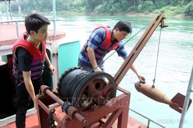 Nhân viên Trạm Khí tượng Thủy văn Chiêm Hóa (Tuyên Quang) đo tốc độ dòng chảy trên sông Lô. Ảnh: Thế Duyệt - TTXVN