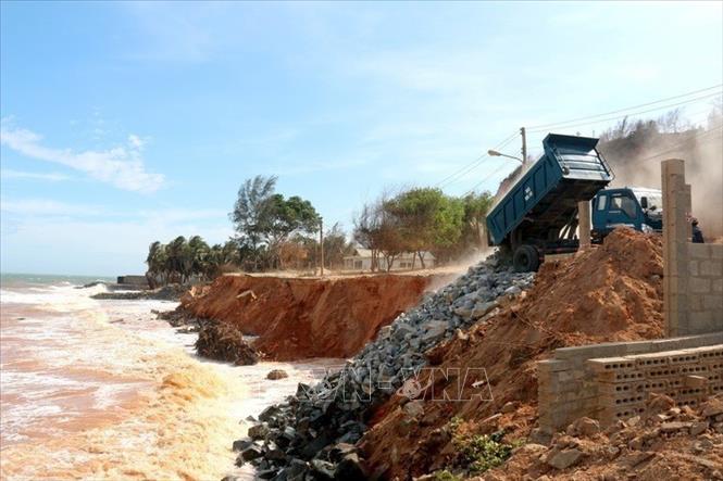 Các xe liên tục đổ đá hộc xuống chân mái bờ biển bị sạt lở để hạn chế lực sóng đánh vào bờ, giảm tối đa sạt lở tại thôn Tiến Đức xã Tiến Thành, thành phố Phan Thiết, Bình Thuận (4/2020). Ảnh: Nguyễn Thanh - TTXVN