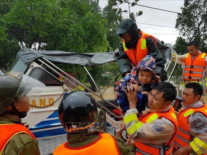 Di chuyển người dân ra khỏi khu vực ngập lũ tại huyện Cam Lộ (Quảng Trị). Ảnh: Thanh Thủy - TTXVN