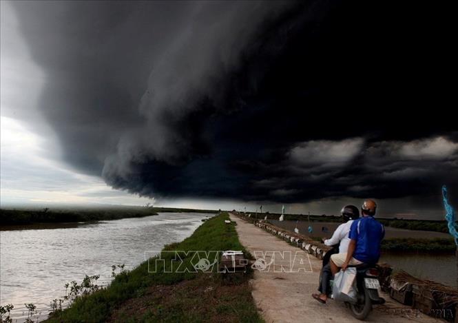Việt Nam được coi là một trong những quốc gia trên thế giới bị ảnh hưởng nhiều nhất vì hiện tượng biến đổi khí hậu, do có đường bờ biển dài và có hướng với bão, lốc, lượng mưa to và thường xuyên biến đổi. Hiện tượng thay đổi khí hậu sẽ ảnh hưởng đến một vài hệ thống tự nhiên của Việt Nam, nền kinh tế cũng như toàn thể dân số. Trong ảnh: Người dân gặp một cơn giông lớn tại Xuân Thủy, Nam Định. Ảnh: An Đăng - TTXVN