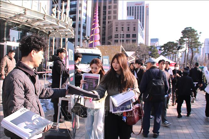 Báo Kyungje Shinmun phát báo miễn phí cho người hâm mộ đến xem buổi diễn của BTS. Ảnh Khánh Vân – TTXVN tại Seoul